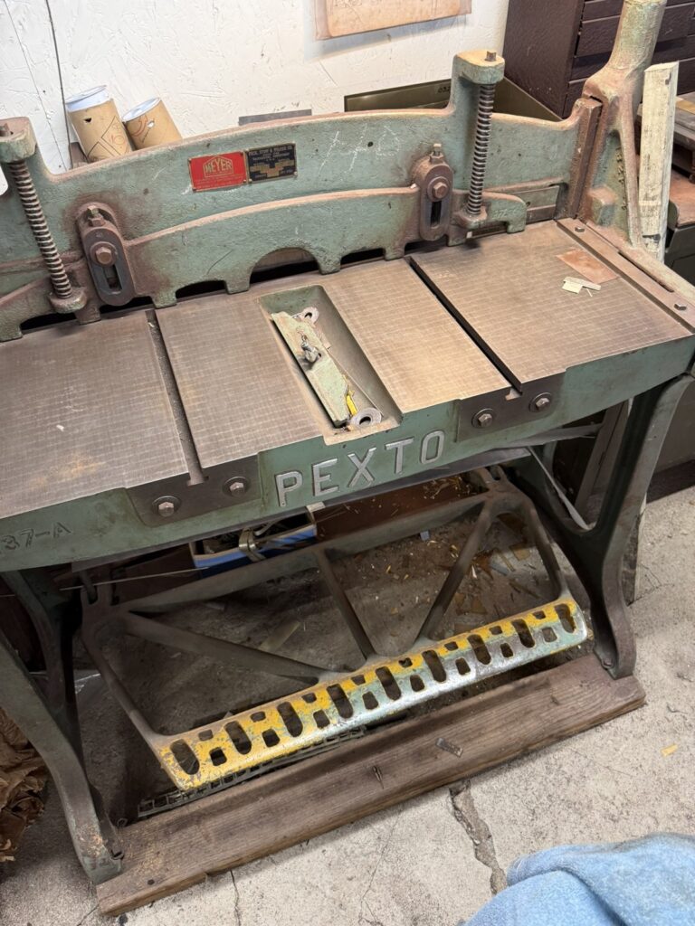 A green Pexto floor shear used to cut sheet silver